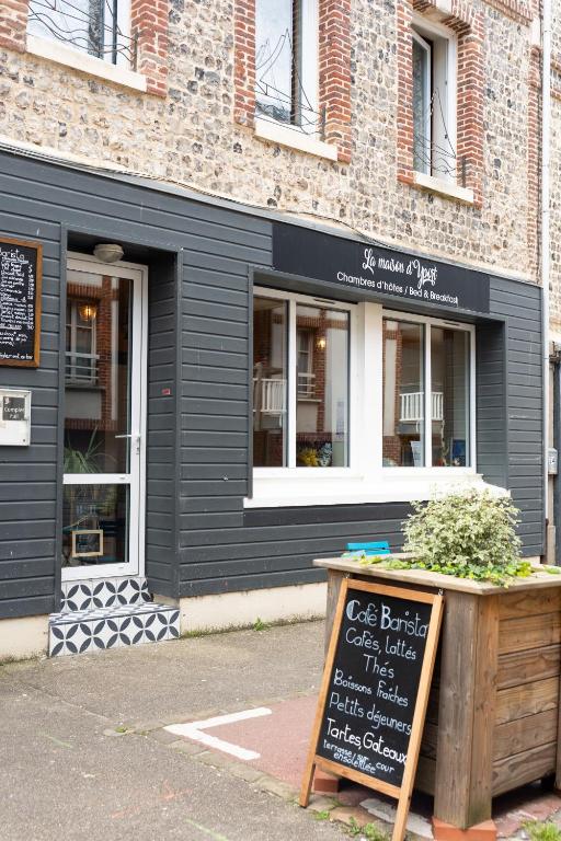 un restaurant noir avec un panneau devant lui dans l'établissement La maison d'Yport, à Yport