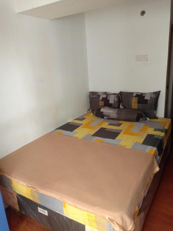 1 cama grande en una habitación con pared en K&G homestay, en Bandung