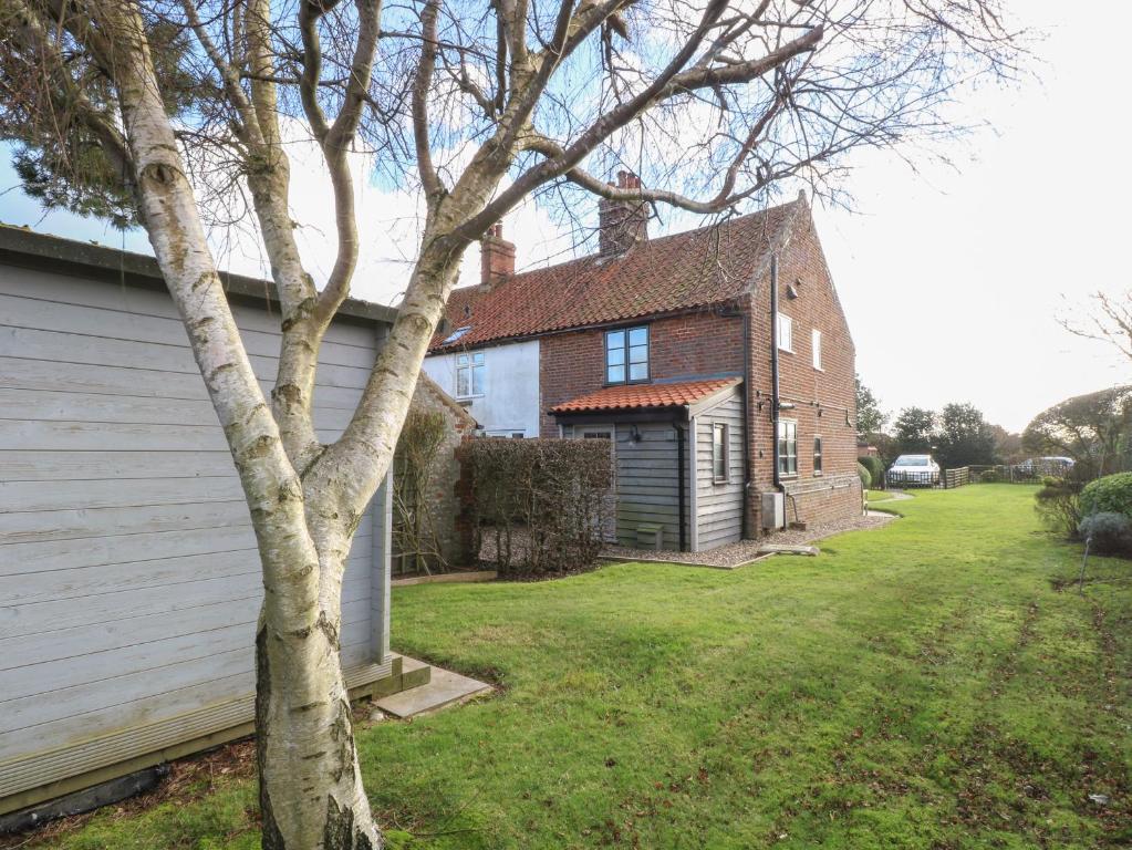 ein Haus mit einem Baum im Hof in der Unterkunft Lanthorn Cottage in Norwich