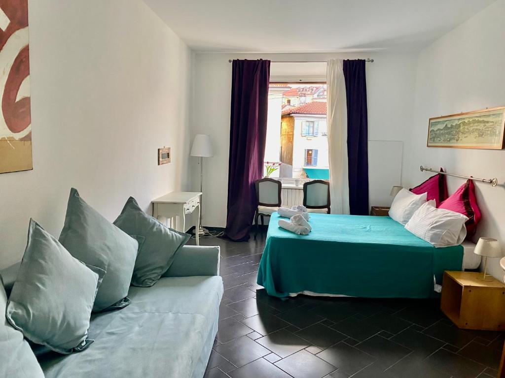 a bedroom with a bed and a couch and a window at Lovelyloft - Ripa Naviglio Grande in Milan