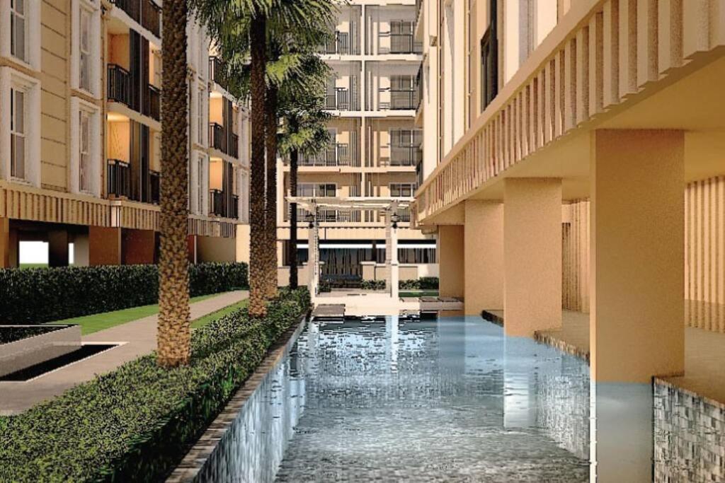 a courtyard with a pool in a building with palm trees at chateau in-town Near Chatuchak in Ban Yang