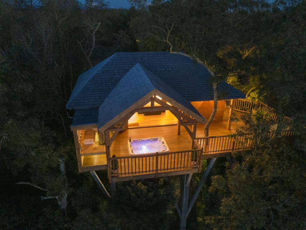 une vue aérienne sur une cabane dans les arbres avec une terrasse dans l'établissement Cabane de Prestige avec Jacuzzi et Sauna privatifs, à Alzonne