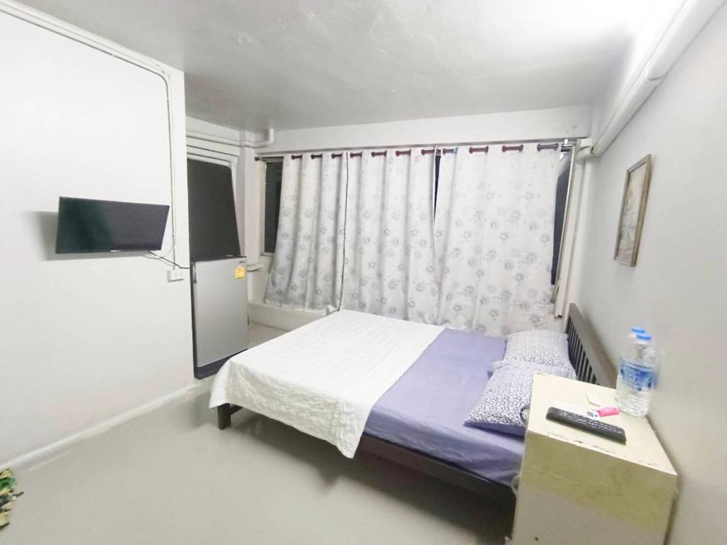 - une petite chambre avec un lit et une fenêtre dans l'établissement ห้องพักสุขสบายวังหลัง, à Bangkok