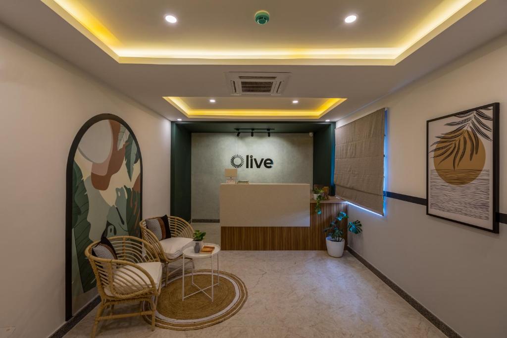 an office lobby with chairs and a give sign on the wall at Olive Hebbal - by Embassy Group in Bangalore