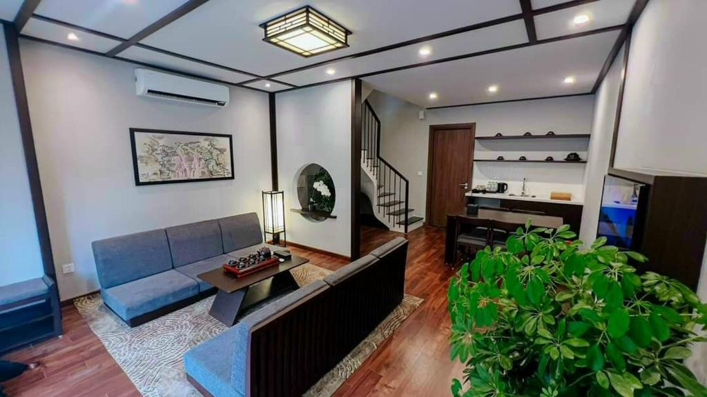 Khoáng nóng Wyndham Thanh Thủy في La Phu: غرفة معيشة مع أريكة زرقاء وطاولة