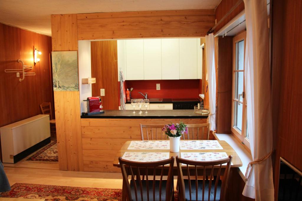 ein Esszimmer mit einem Tisch und einer Küche in der Unterkunft Chalet Schwendihus - CharmingStay in Flumserberg