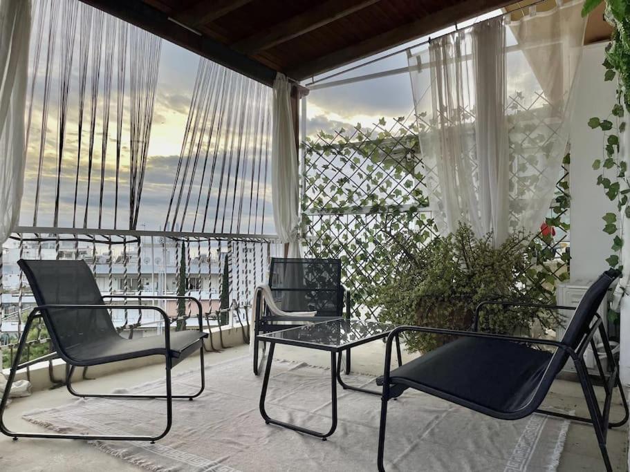 2 Stühle und ein Tisch auf dem Balkon in der Unterkunft Sea view penthouse with huge terrace in Athen