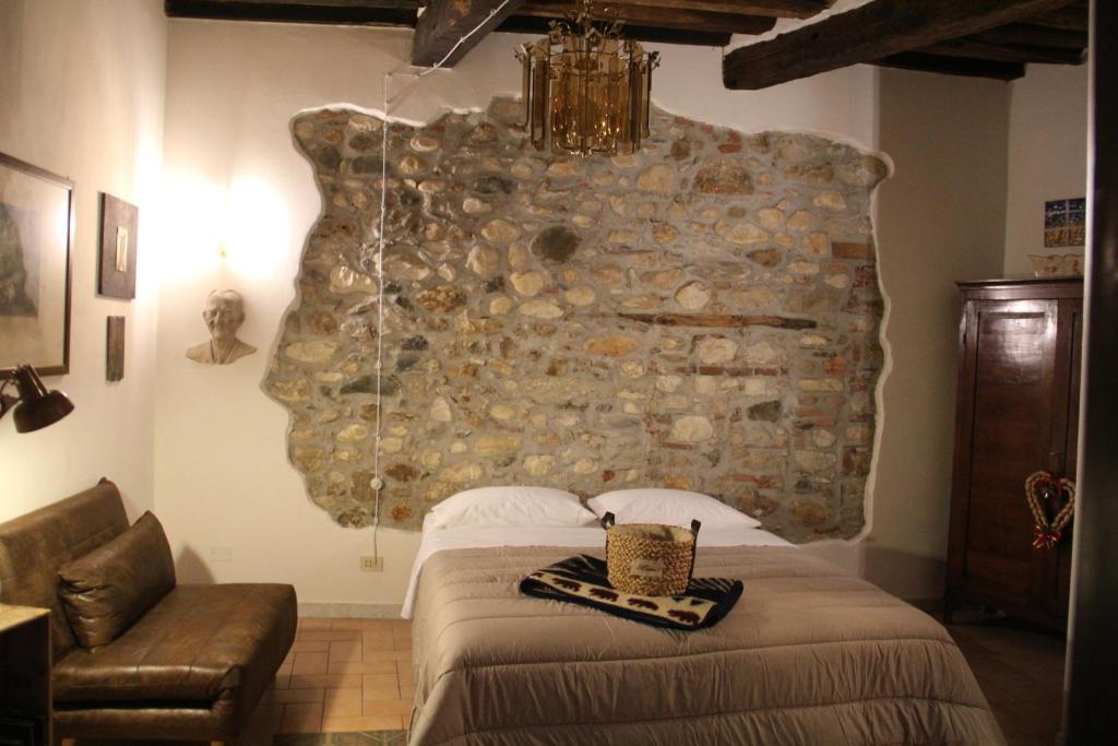カッラーラにあるLa Porta sui Monti di Lunaの石壁のベッドルーム1室(ベッド1台付)