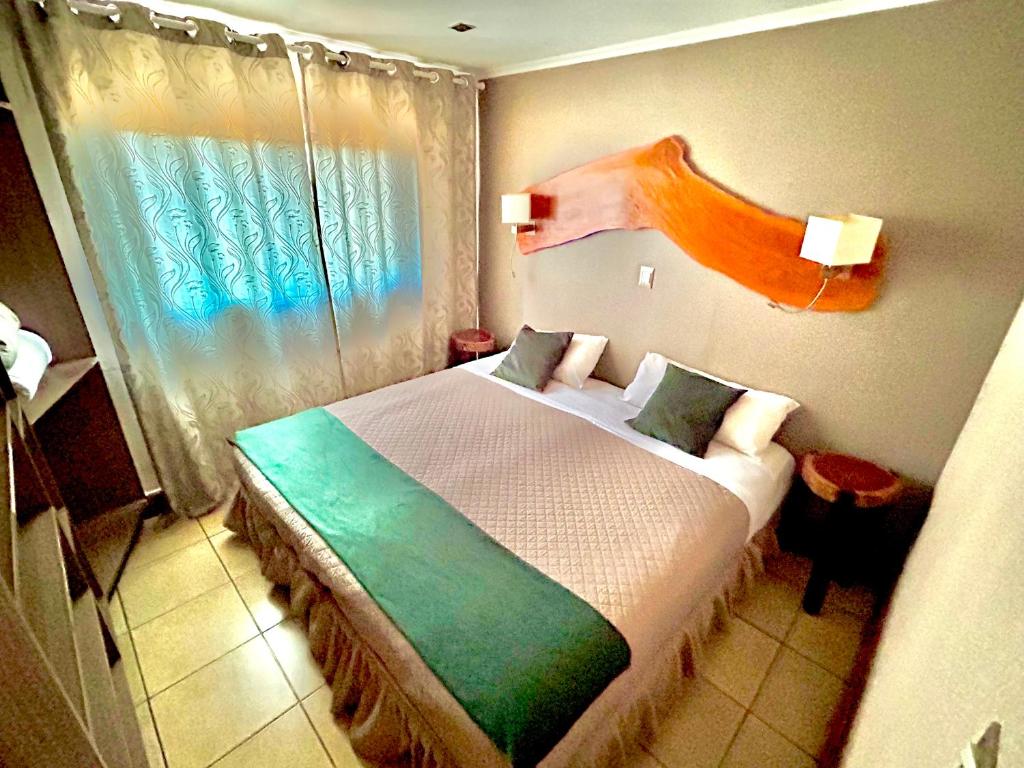 1 dormitorio con 1 cama grande y ventana en Tupa hotel iguazu en Puerto Iguazú
