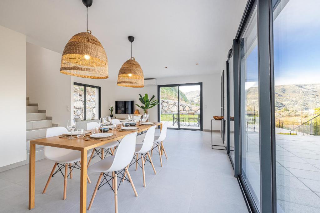 une salle à manger avec une grande table en bois et des chaises blanches dans l'établissement Villa Riviera - Nouveaute entre mer et montagnes, à Colomars