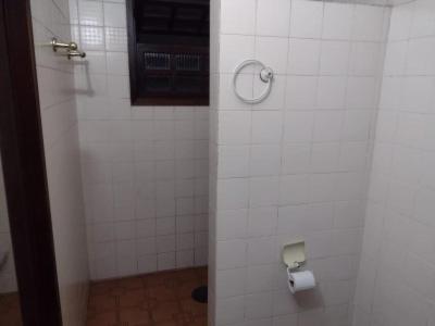 Baño de azulejos blancos con dispensador de papel higiénico en Hostel Recanto Caiçara, en São Sebastião