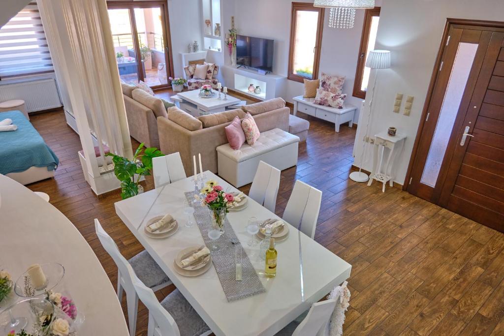 a living room with a white table and chairs at Elena Luxury Suite Agios Stefanos in Agios Stefanos
