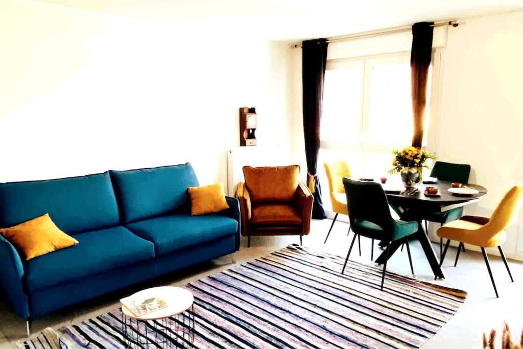 a living room with a blue couch and a table at Luxury à 10mn du Centre de Paris & Free Parking in Vitry-sur-Seine