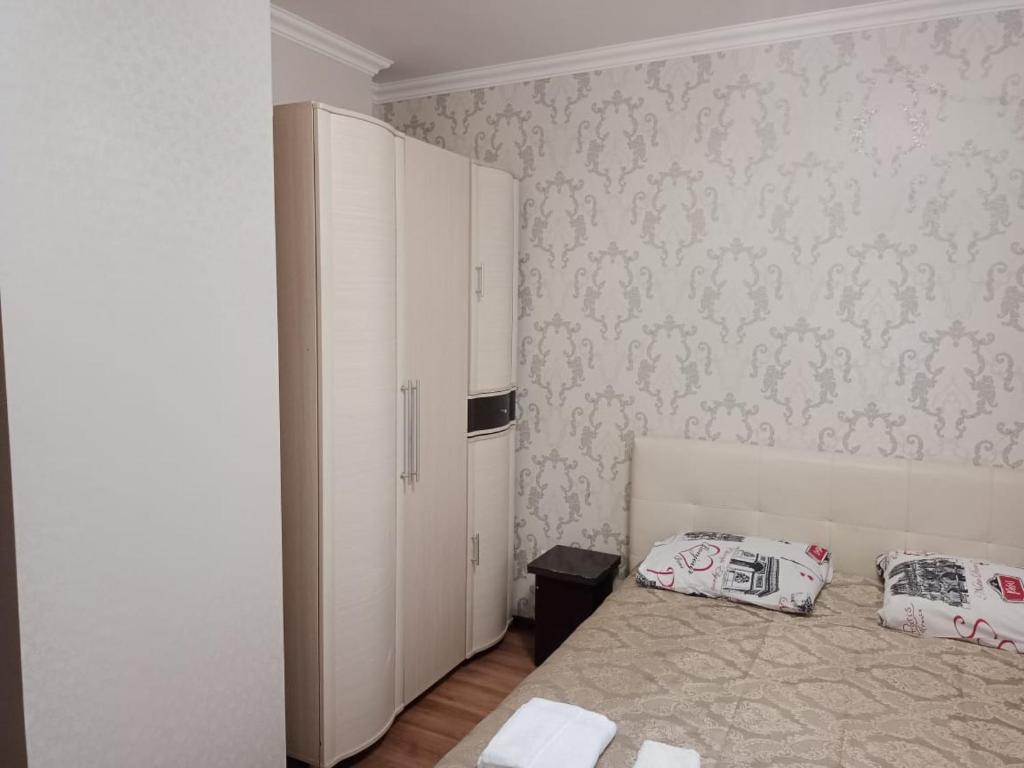 - une chambre avec un lit et une armoire blanche dans l'établissement Квартира, à Astana