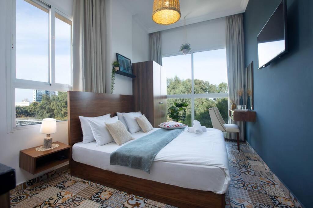 ein Schlafzimmer mit einem großen Bett und einem großen Fenster in der Unterkunft Em Shadi's Studio in Mar Mikhael in Beirut