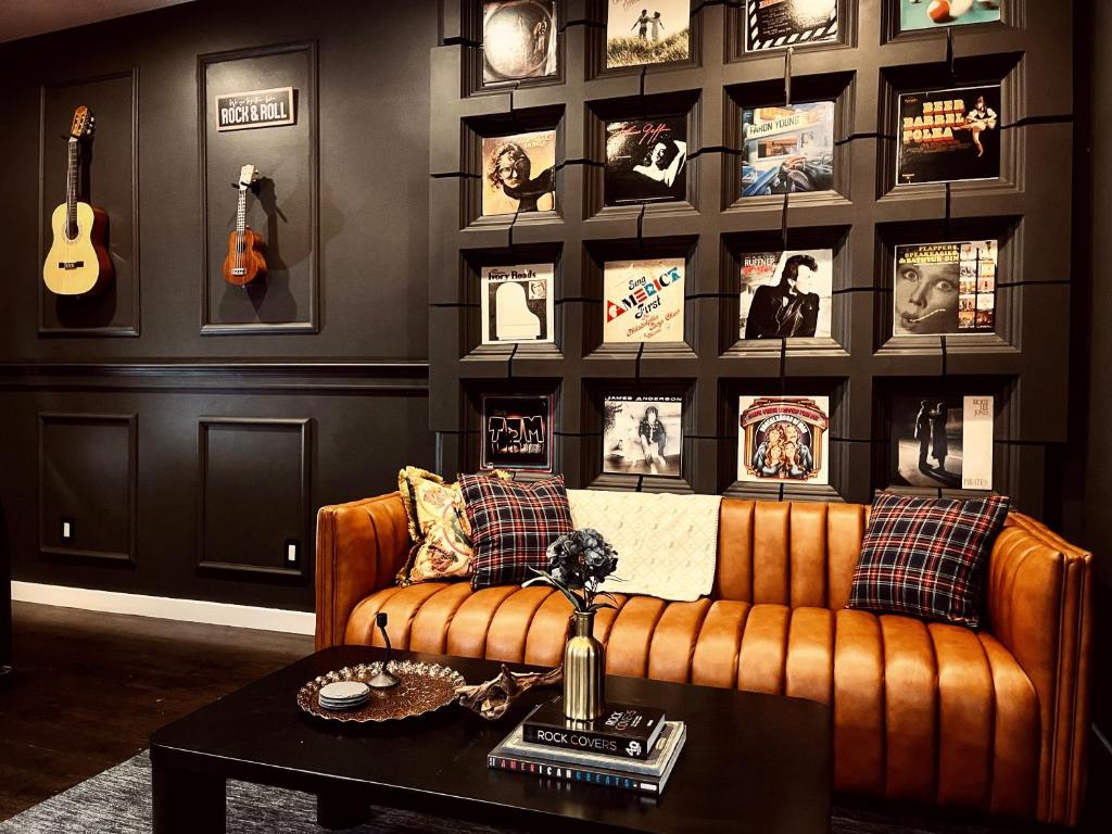 uma sala de estar com um sofá e uma parede com fotografias em Trio Sonata, 3-Bed Rock n Roll Residence in Northern Liberties em Filadélfia