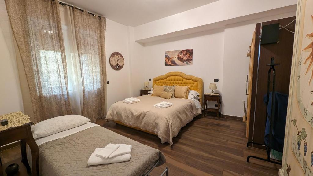 a bedroom with two beds and a clock on the wall at B&Bobo in Salerno