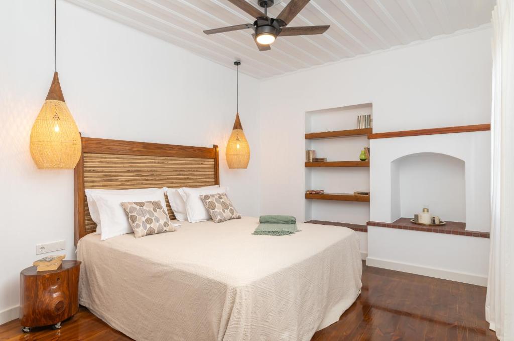 - une chambre avec un lit et un ventilateur de plafond dans l'établissement Keepos by Polykratis, à Kokkari