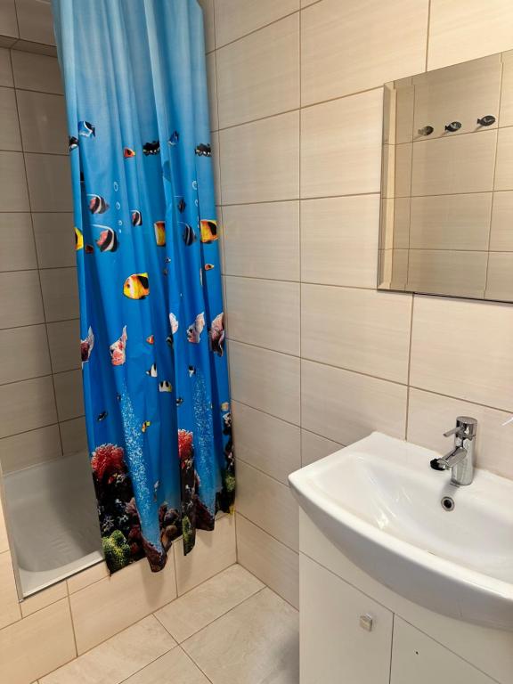 a bathroom with a shower curtain with fish on it at Willa Irena in Świnoujście