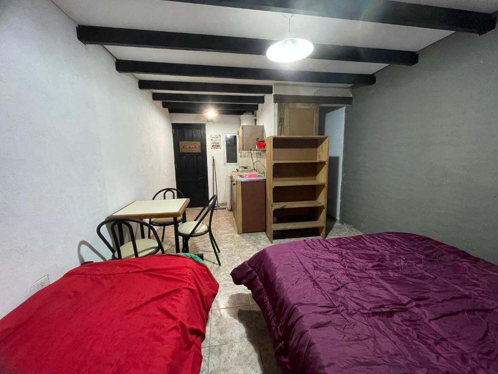 a room with a bed and a table and a desk at Monoambiente para 3 in Santa Teresita