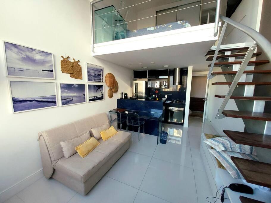 a living room with a couch and a staircase at Lindo Loft Beira-Mar na Vitória in Salvador