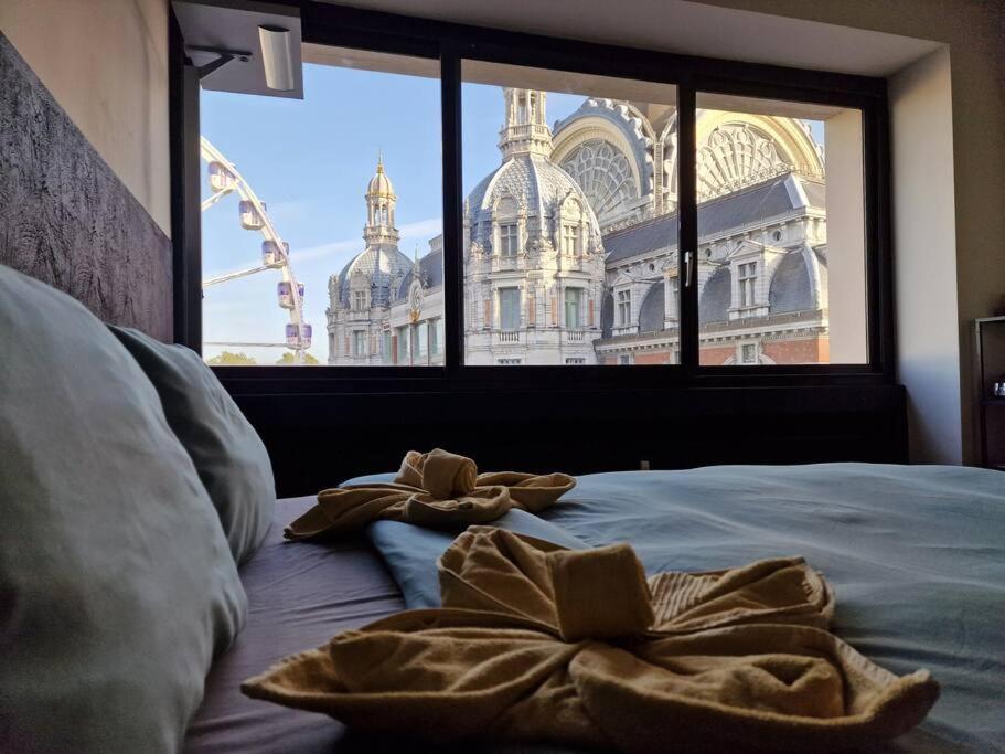 a bed with towels on it with a large window at Stunning View + Japan Design Bed @ Central Station in Antwerp