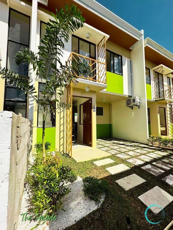 dom z palmą przed nim w obiekcie Lovely Homes at Casa Mira Bacolod w mieście Bacolod