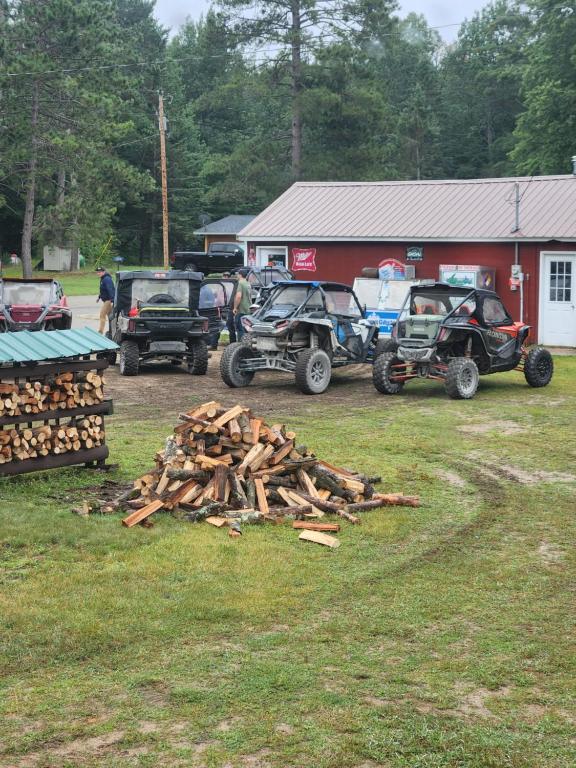 a pile of wood in front of a group of vehicles at cabin 3 in Steuben