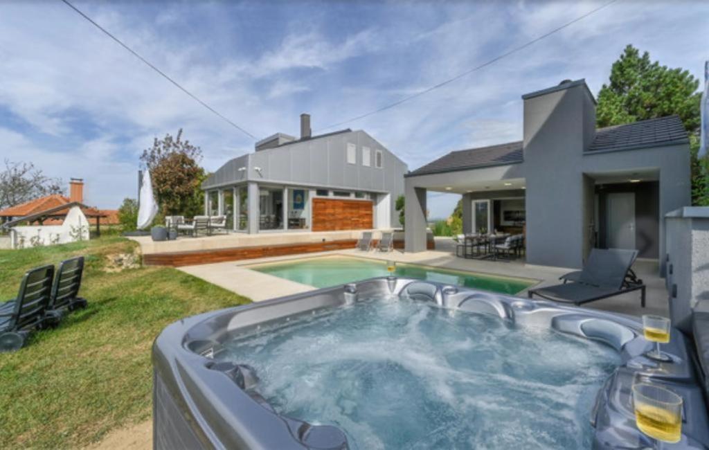 ein Haus mit einem Pool vor einem Haus in der Unterkunft Villa Darabos in Varaždin Breg