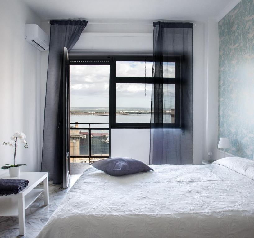 a bedroom with a bed and a large window at Acqua Holiday House in Taranto