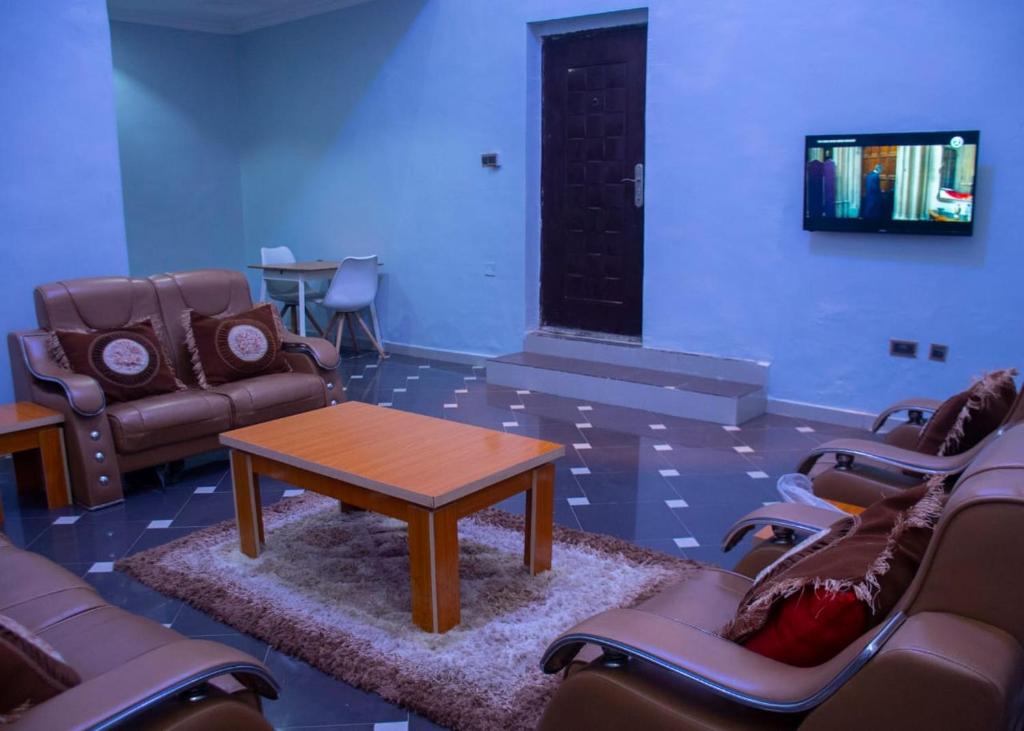 una sala d'attesa con divani, tavolo e sedie di Home to home luxury apartments and suites a Benin City