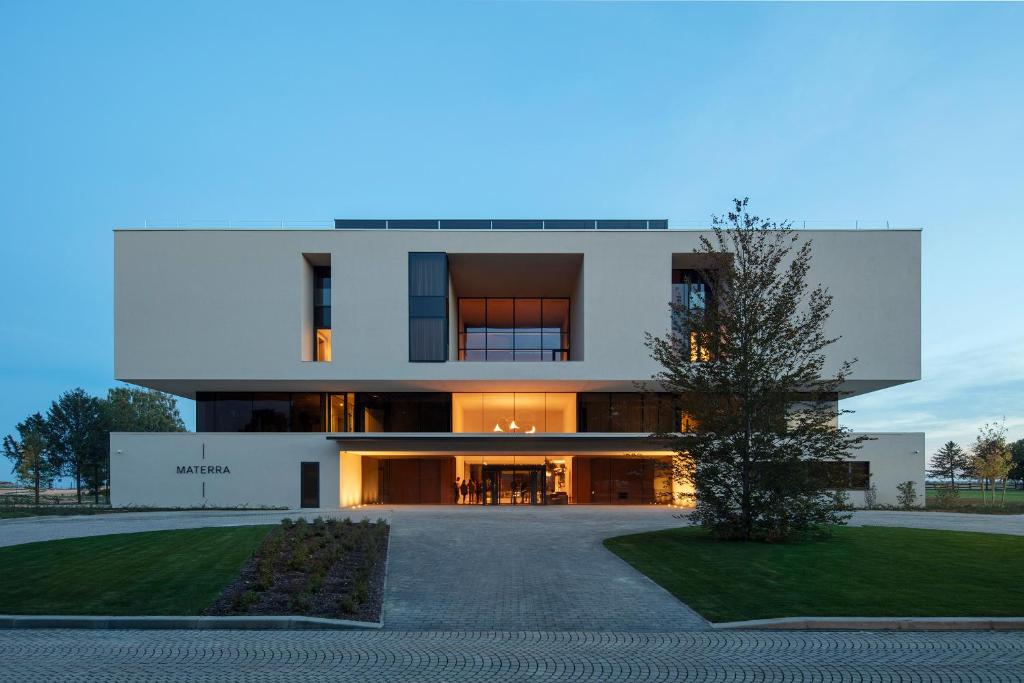 a large white building with a driveway at Hotel Materra in Osijek