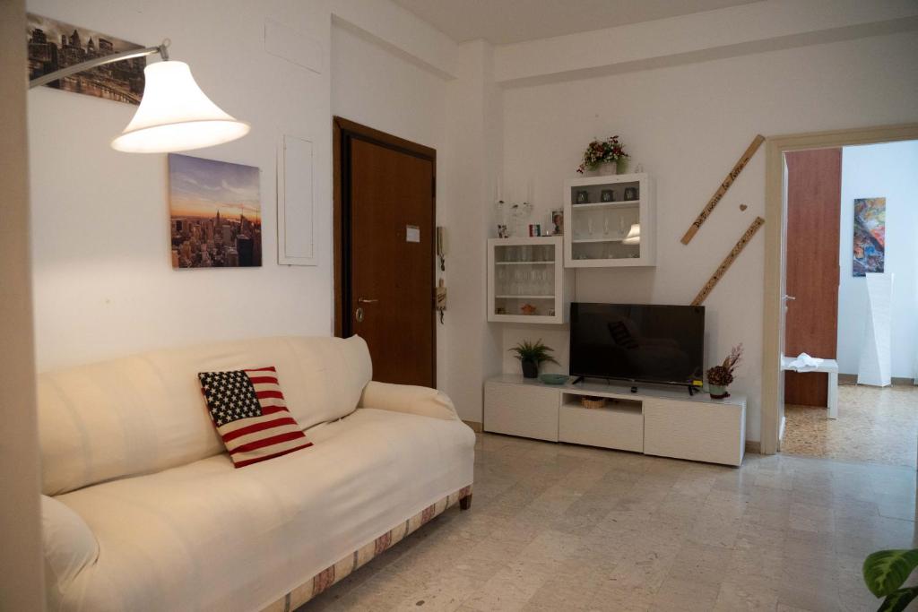 a living room with a white couch and a television at Discover Sustainable Bliss: 2-BR Apartment in Rome in Rome