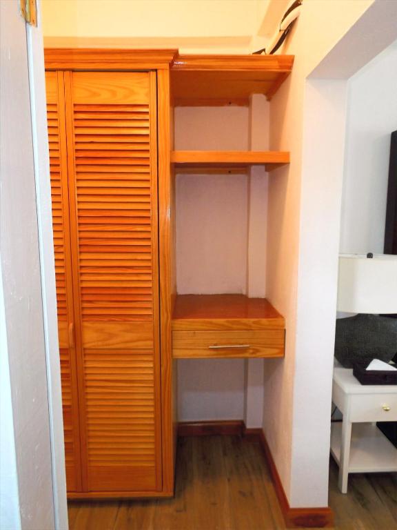 a closet in a room with wooden shelves at Basil At Villa in Arnos Vale