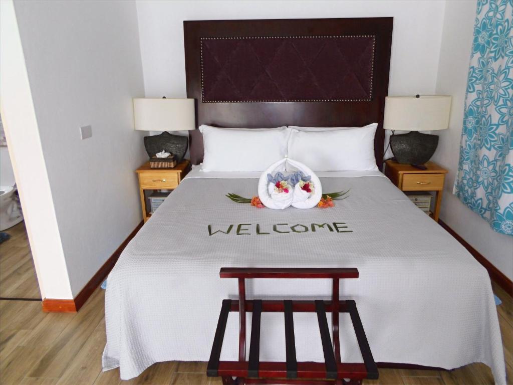a hotel room with a bed with a welcome sign on it at Basil At Villa in Arnos Vale
