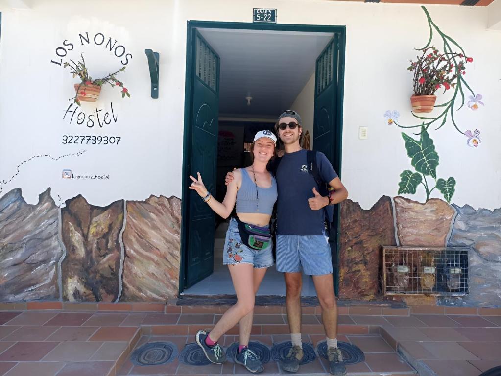 a man and a woman standing in front of a door at Los Nonos Hostel in Guadalupe