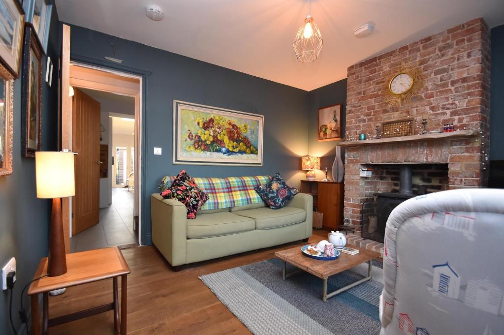 a living room with a couch and a fireplace at May's House in Rye Harbour