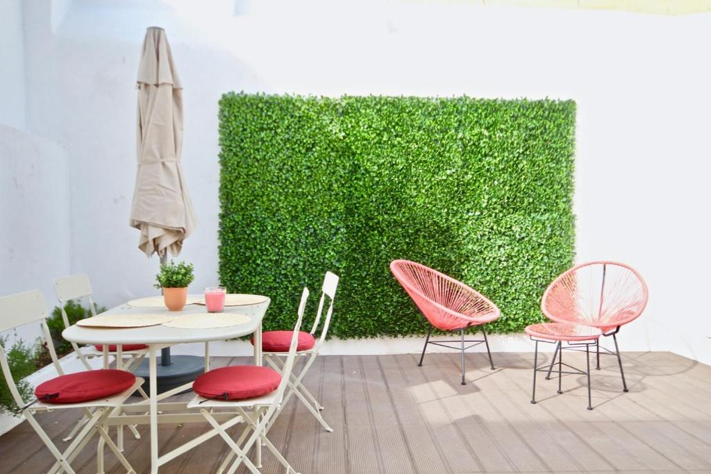 a table and chairs in front of a green wall at Akicity Santos Sunrise in Lisbon