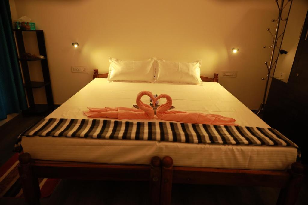 ein Bett mit zwei rosa Handtüchern drauf in der Unterkunft Marari Sophy Villa in Mararikulam