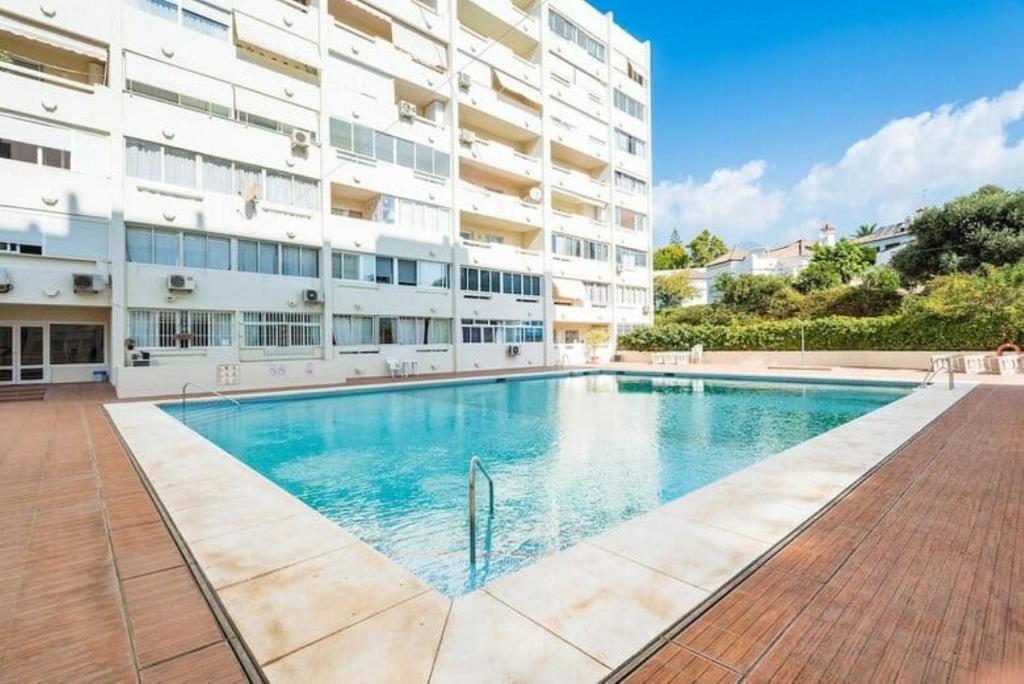 a swimming pool in front of a building at Apartamento Marbelsun ll in Marbella
