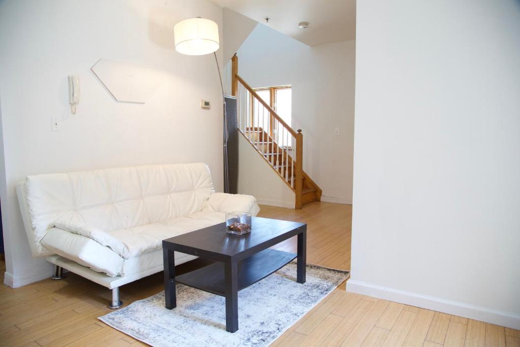 a living room with a white couch and a table at BrightonBeach-Comfy Room-Close Ocean in Brooklyn