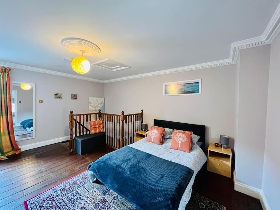 ein Schlafzimmer mit einem Bett mit einer blauen Decke in der Unterkunft Characterful & cosy cottage with large double room in Manningtree