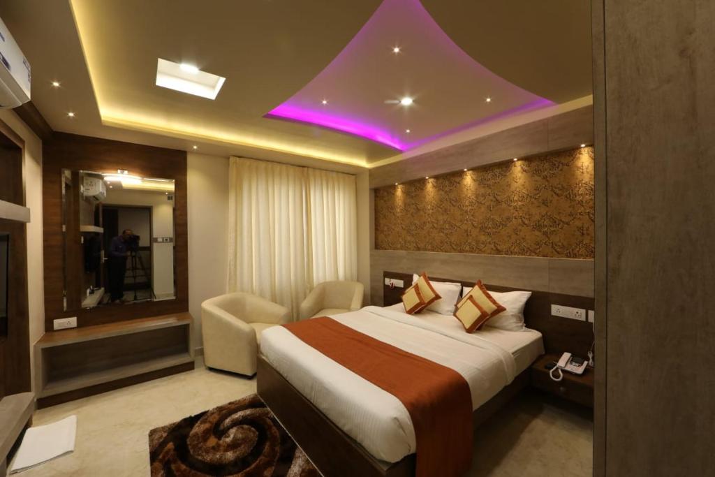 a hotel room with a large bed and a purple ceiling at Elevar Ayanna in Bangalore