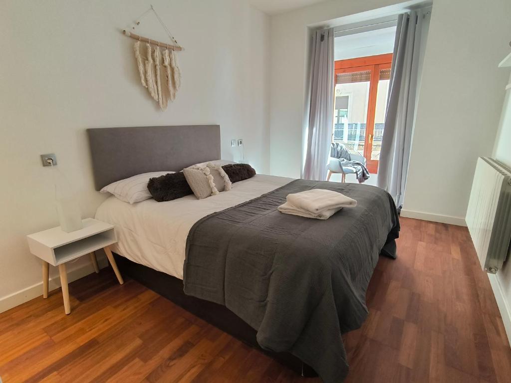 1 dormitorio con 1 cama grande y suelo de madera en El Mirador de Alfonso I by Alogest, en Zaragoza