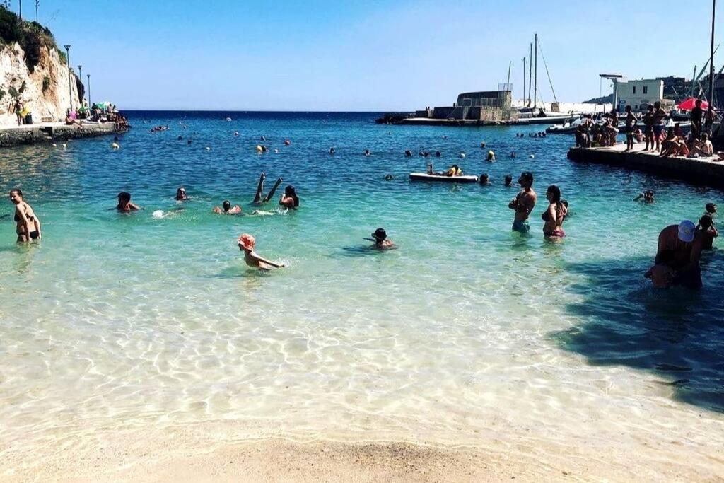 Al Porto, casa vacanze 100mt dal mare في مارينا بورتو: مجموعة من الناس في المياه على الشاطئ