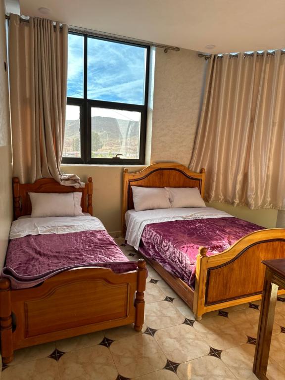 two beds sitting in a room with a window at HOTEL NOSTRESS in Khenifra