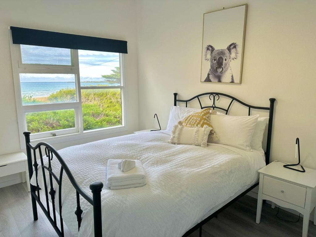 1 dormitorio con 1 cama con una foto de perro en la pared en Seaspray Beach House - Pet Friendly - 50m to Beach, en Apollo Bay