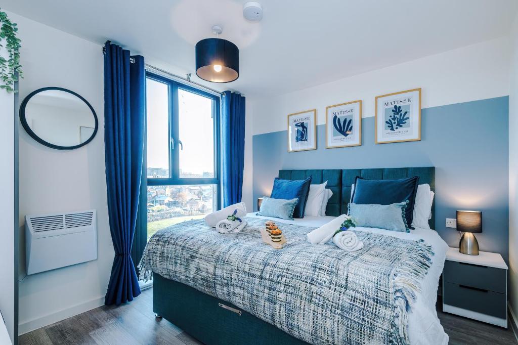 a bedroom with a large bed with blue curtains at NEW! Stunning 2-bed apartment in Liverpool by 53 Degrees Property - Amazing location, Ideal for Small Groups - Sleeps 4! in Liverpool
