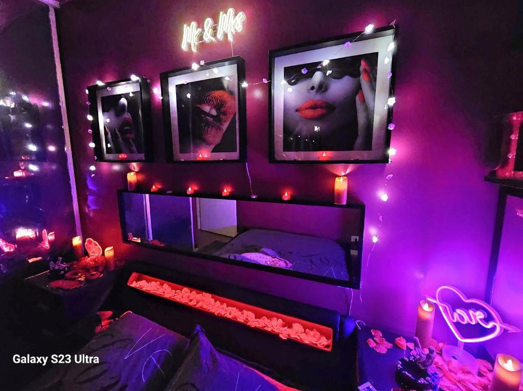 una camera con luci viola e un letto con specchio di Love Room Amour Glamour Lib proche gare rer 5 minute à pied ad Aulnay-sous-Bois