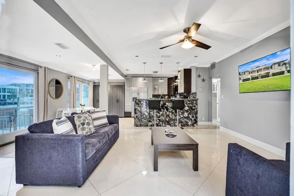 a living room with a couch and a ceiling fan at Beach Isles Modern 1BR Waterfront Apartment with Patio in Fort Lauderdale